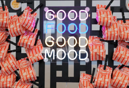 Sign displaying the words good food good mood surrounded by popcorn bags