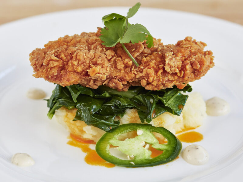 A battered and fried cultured meat, a cultured chicken cutlet, plated with sauteed greens and mashed root vegetables | image courtesy of upside foods