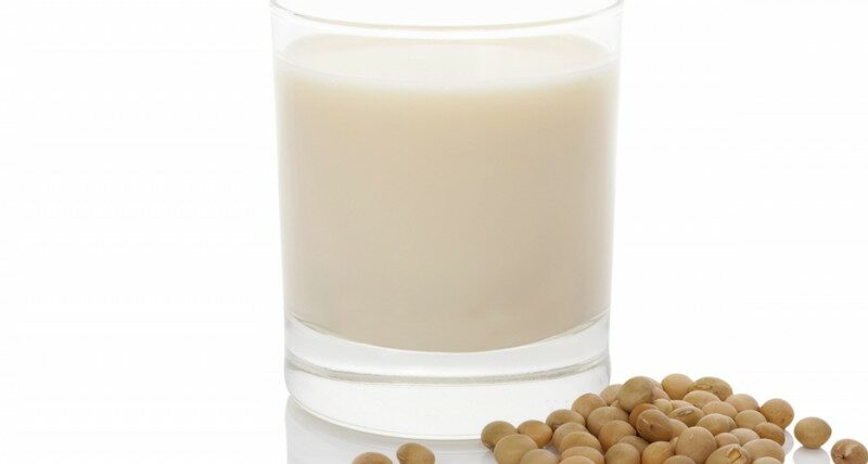 Glass of milk next to soybeans