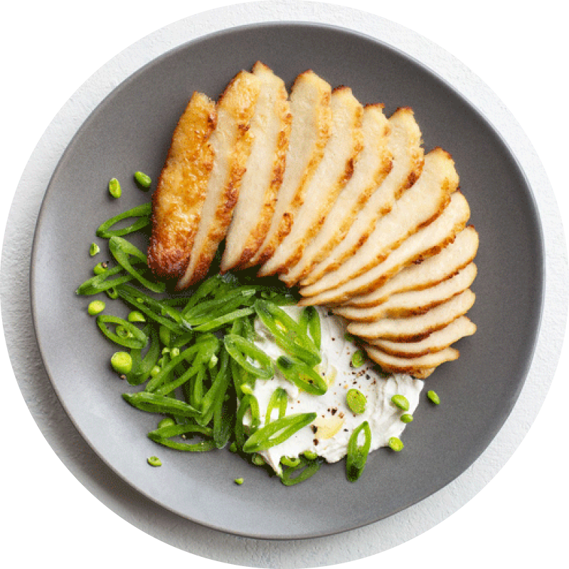 Grilled cultured meat, cultured chicken by upside foods sliced and plated with a puree and scallions on a grey plate