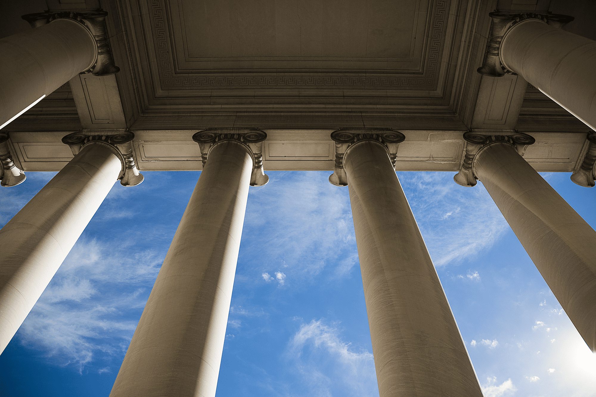 Looking up through legislative building columns at sky